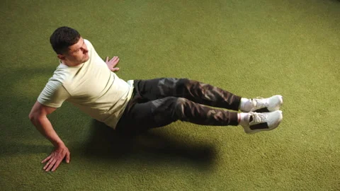 Athletic Man Performing Abdominal Exercises on Gym Floor, Core Workout Focus Stock Footage 269207219