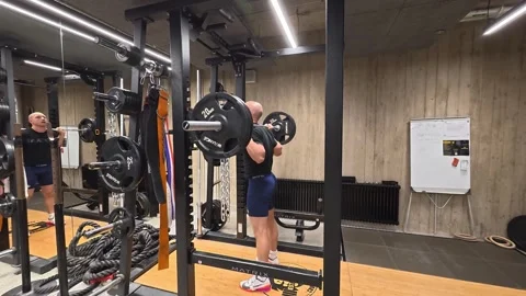 Athletic Man Performing Barbell Squat in Power Rack During Stock Footage 328809940