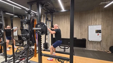 Athletic Man Performing Barbell Squat in Power Rack During Stock Footage 328809974
