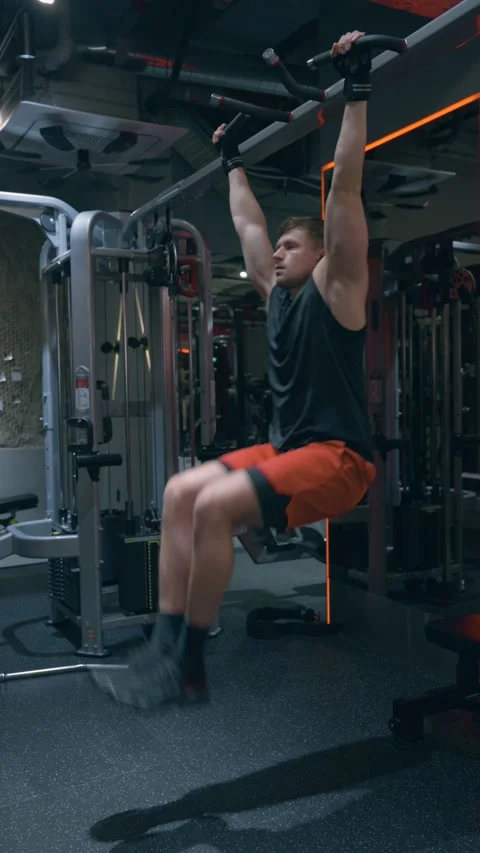 Athletic Man Performing Hanging Leg Raises With Oblique Twists for Core Stock Footage 334343685