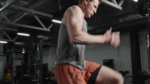 Athletic Man Performing High Knees Cardio Workout in Gym Stock Footage 339886185