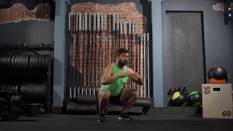 Athletic man performing squats exercise in gym Stock Footage 124830322