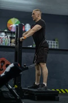 Athletic man performing squats in a modern gym environment focused on strength Stock Photos
