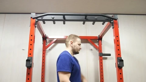 Athletic man performing strength exercise for upper-body on pull up bar at gym 動画素材 122822591