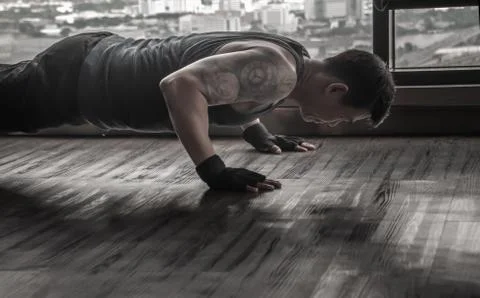 Athletic man performs push-up exercises in the gym, Muscular and strong guy e Stock Photos