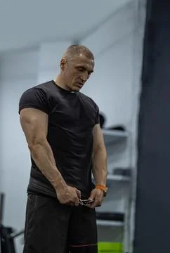 Athletic man performs squats focusing on form and strength in a fitness gym Stock Photos