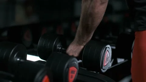 Athletic man picking up dumbbells Stock Footage 142279746