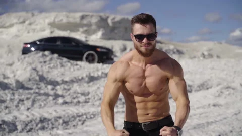 Athletic man posing on camera. Strong bodybuilder without shirt  Stock Footage 141988460