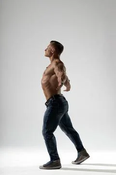 Athletic man posing in studio against a neutral background showcasing strength Stock Photos