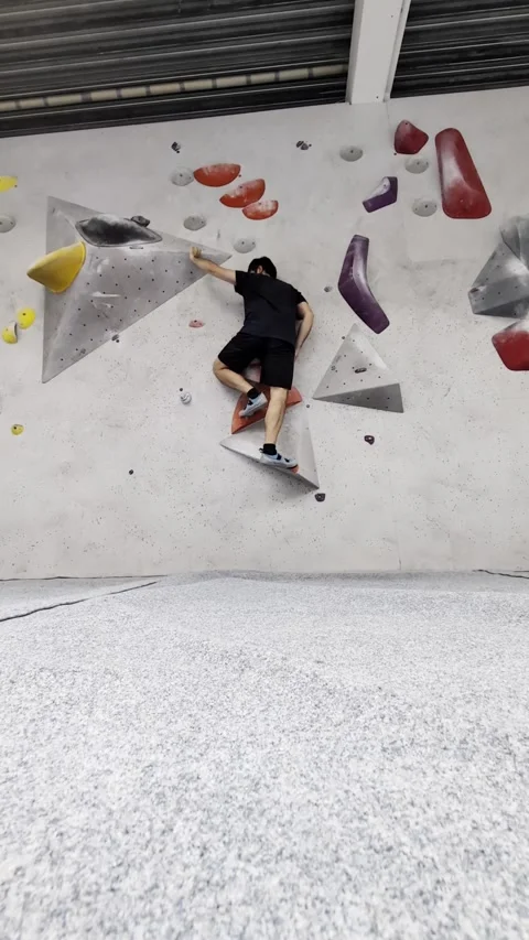 Athletic man practicing bouldering on artificial wall in modern gym Video stock 335637575