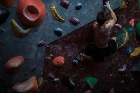 Athletic man practicing in a bouldering gym Stock Photos