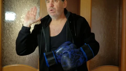 Athletic man practicing martial arts and boxing strikes at home Stock Footage 327868087