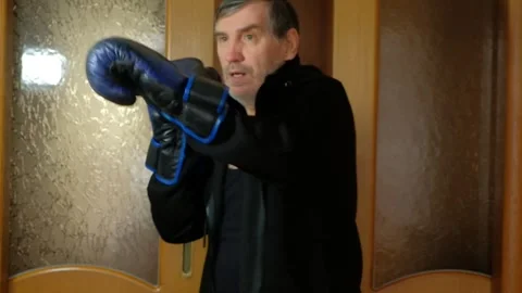 Athletic man practicing martial arts and boxing strikes at home Stock Footage 327868250
