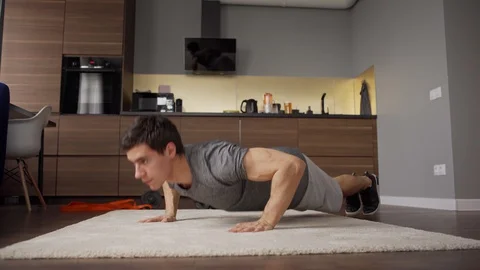 Athletic man practicing push up exercise at home Stock Footage 128756889
