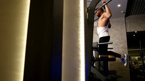 Athletic Man Pulling up on Horizontal Bar in Fitness Gym Stock Footage 75367691