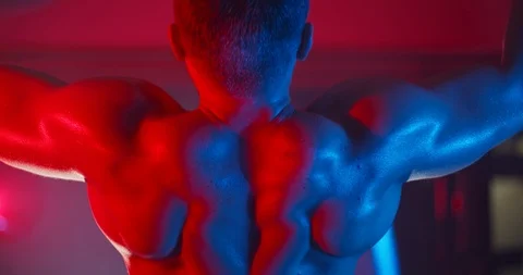 Athletic man pulls up on the crossbar in the gym concept lighting Stock Footage 126559069