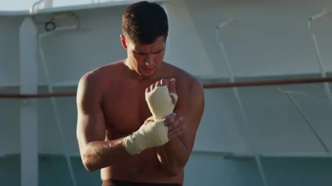 Athletic man puts on hands wraps for boxing workout Stock Footage 196203232