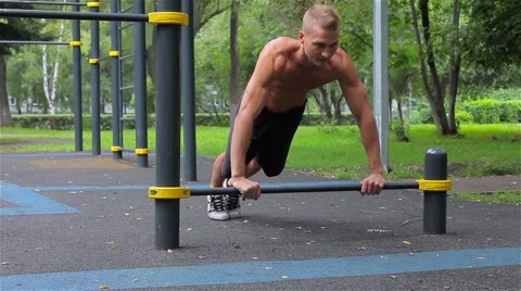 Athletic man quickly pushed off the crossbar in City Park. Workout 스톡 동영상 66420727