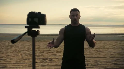 Athletic man records video lessons on camera he is standing in front of the  Stock Footage 200117679