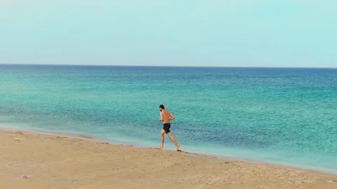 Athletic man run barefoot on sand beach ocean running. Runner people. Sport. Stock Footage 151657738