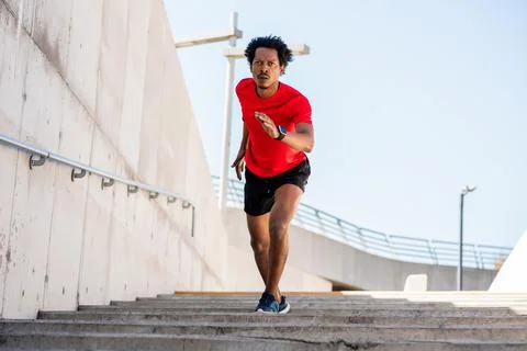 Athletic man running and doing exercise outdoors. Stock Photos