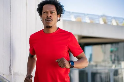 Athletic man running and doing exercise outdoors. Stock Photos