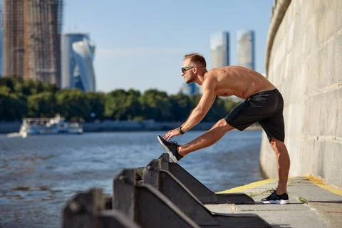 Athletic man running and doing functional workout outdoors - Sportive adult male Stock Photos