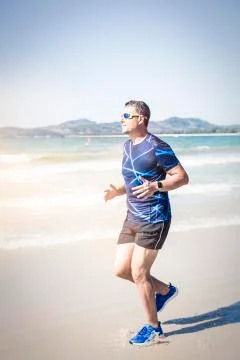 Athletic man running on the beach Foto stock