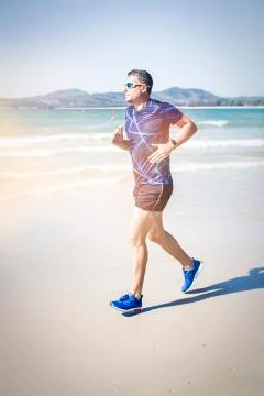 Athletic man running on the beach Foto stock