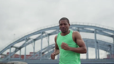 Athletic man running down urban bridge Stock Footage 117064727