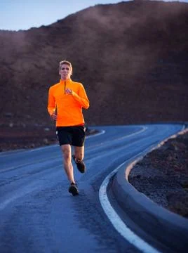 Athletic man running outside, training outdoors. jogging on road Stock Photos