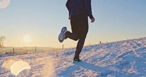 Athletic man Is Running Through The Snow - slow motion Stock Footage 146536110
