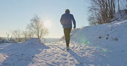 Athletic man Is Running Through The Snow - slow motion Stock Footage 146538388