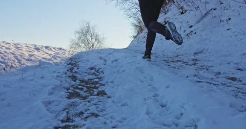 Athletic man Is Running Through The Snow - slow motion Stock Footage 146539261