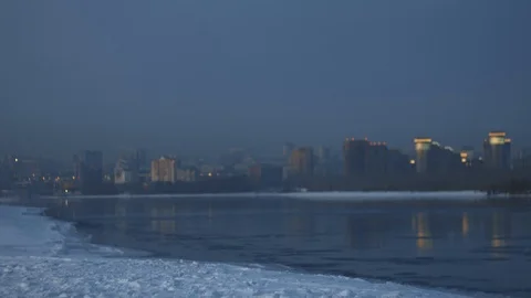 Athletic man running to winter river bank with cityscape view. Goal achievement Stock Footage 102324347