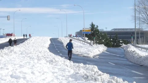 Athletic man runs on asphalt after a heavy snowfall at theLas Tablas Stock Footage 146332917