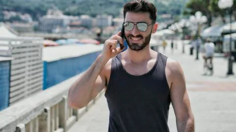 Athletic man at the seaside calling on cell phone Stock Photos