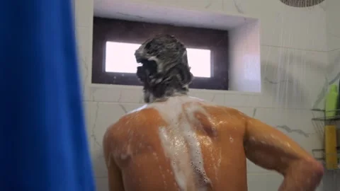 Athletic man showers post run, dancing and rinsing off fatigue. Video stock 307887720