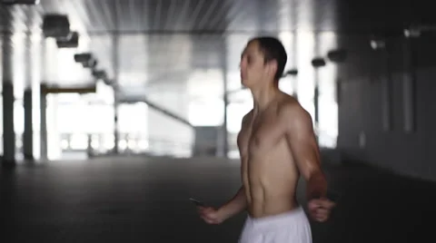 Athletic man skipping with a jump rope. 4K Stock Footage 64055837