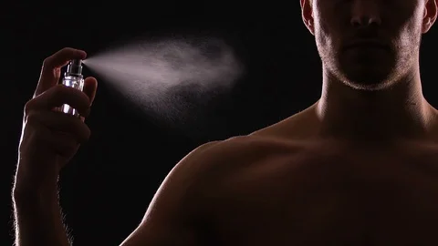 Athletic man spraying perfumes on torso, seductive fragrance for dating, slow-mo Stock-Footage 105044412