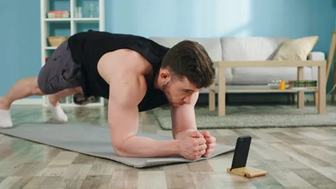Athletic Man Is Standing In Elbow Plank at Home Stock Footage 135320810