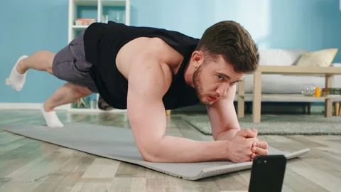 Athletic Man Is Standing In Plank and Using Gadget Stock Footage 135324368