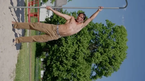 Athletic man stretching before training in the park, Vertical video. Slow motion Stock Footage 244347661