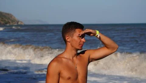 Athletic man in surf waves on the beach 스톡 사진