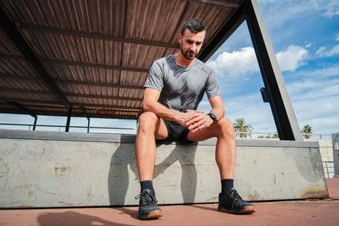 Athletic Man Taking a Break After Intense Workout, Reflecting on Fitness Jo.. Stock Photos