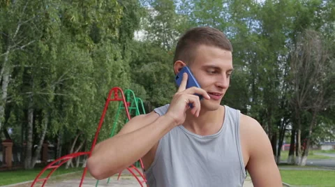 Athletic man talking use smartphone in the outdoors close up Stock Footage 65614177