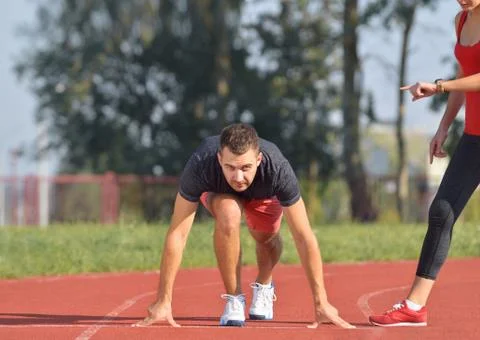 Athletic man on track ready to run. Healthy fitness concept with active Stock Photos
