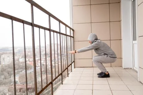 Athletic man in training clothes performs an exercise on the legs squat Stock Photos