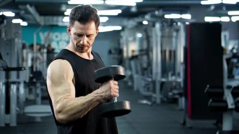 Athletic man training with dumbbells. Physical and muscle weight training Stock Footage 279924214