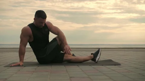 Athletic man training outdoors, doing stretching exercises  Stock Footage 200117746